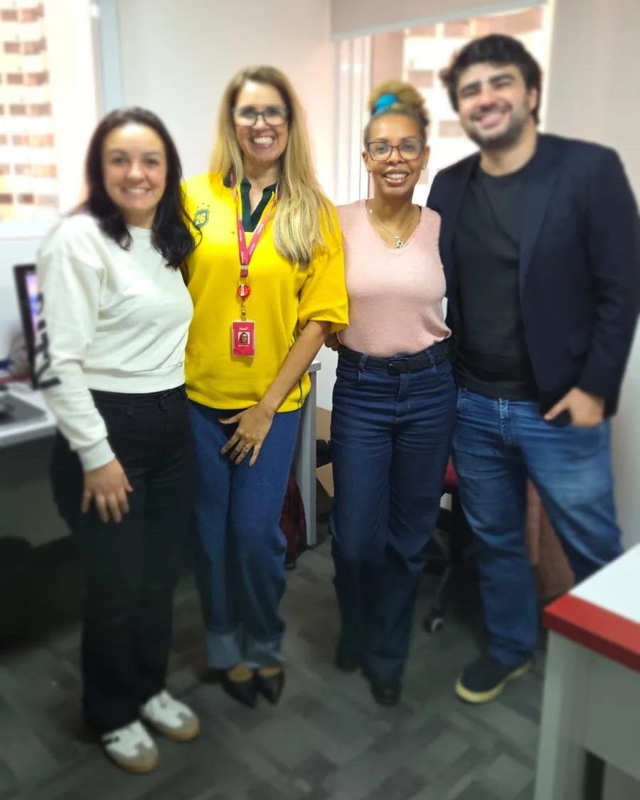 Quatro integrantes da equipe Apex lado a lado no escritório