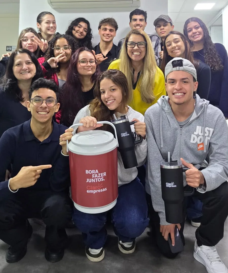 Equipe de consultores da Apex reunida no escritório, com um cooler Claro empresas escrito Bora fazer juntos